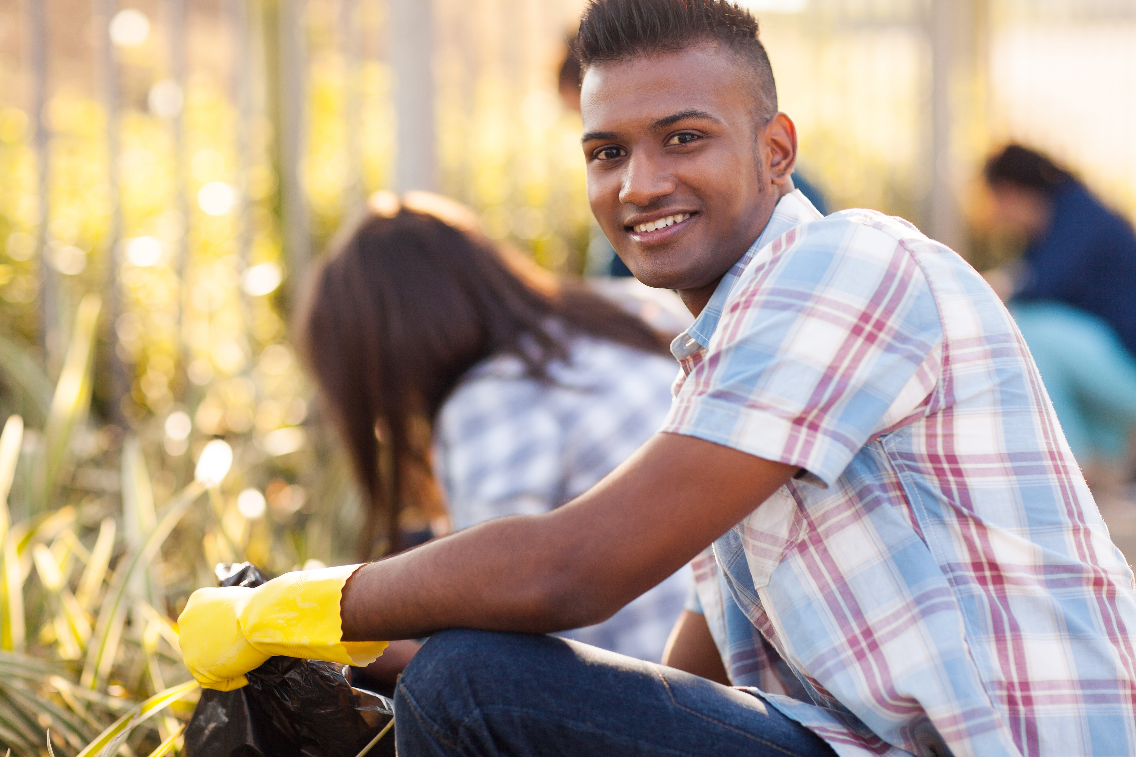 handsome teen volunteer cleaning streets with friends